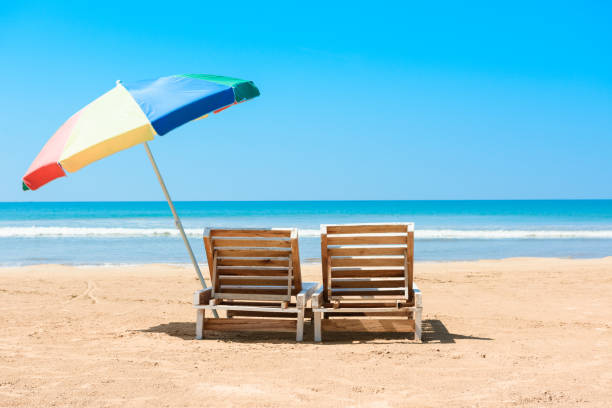 istock Two wooden beach chairs and umbrella 804552200