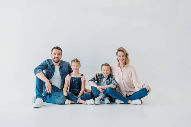 istock smiling family looking at camera while sitting together on the floor 804554746