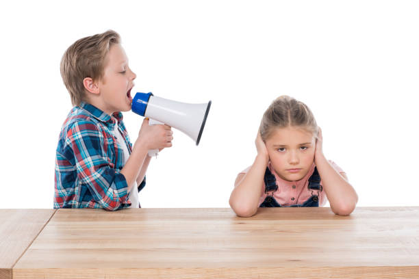 istock angry boy with megaphone yelling on his sad sister isolated on white 804555118