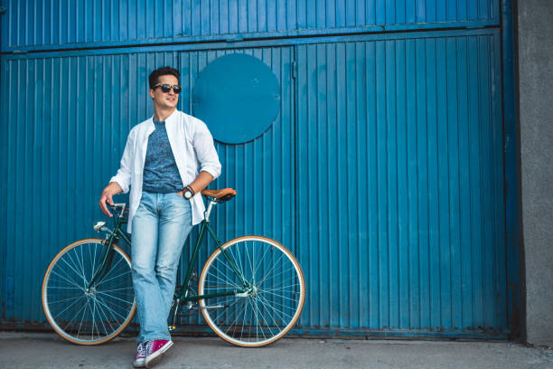 istock Man with bicycle leaning on blue garage door 804559336