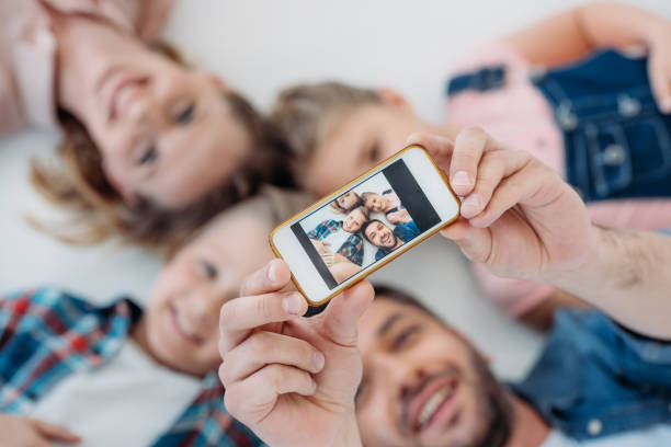 istock happy caucasian family smiling while taking selfie on smartphone 804575352