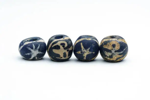 Photo of Ancient blue bird glass beads on white background