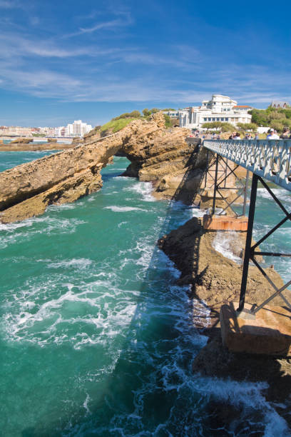 marcher sur la magnifique passerelle menant au rocher de la vierge sur la côte atlantique avec les falaises et l’océan turquoise à biarritz, pays basque, france - rocher de la vierge photos et images de collection