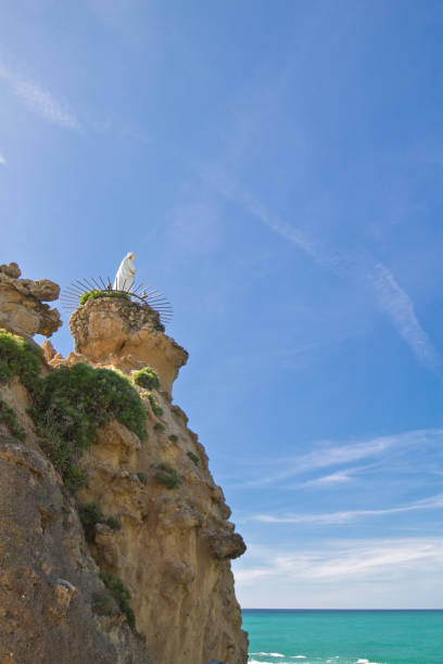 rocher de la vierge statue de la vierge marie au sommet de la falaise sur la côte atlantique dans un ciel bleu à biarritz, pays basque, france - rocher de la vierge photos et images de collection