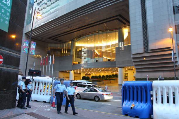Barricades and police officers on Harbour Road, Wanchai, Hong Kong Island, on the first day of President Xi Jinping's visit On the first day of President Xi Jinping's visit to Hong Kong for the 20th anniversary of the handover of Hong Kong to China, Hong Kong's police officers were seen working with the security systems that they installed - giant barricades to control the spaces in Wanchai and the use of the small doorways/ gates meant a careful control of any vehicles passing through such points. This is Harbour Road. xi jinping stock pictures, royalty-free photos & images