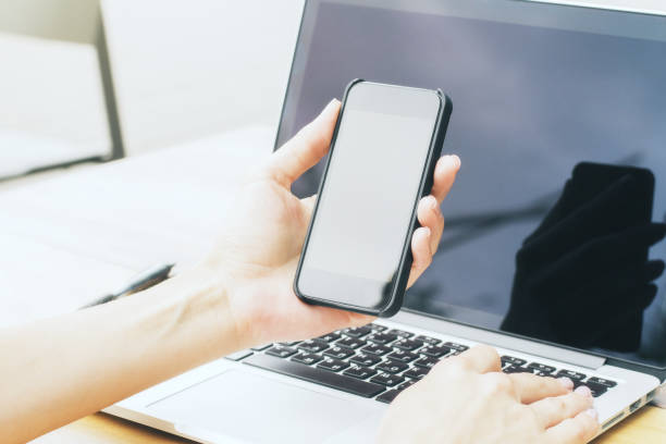 istock Businesswoman holding smartphone and using laptop 804600414