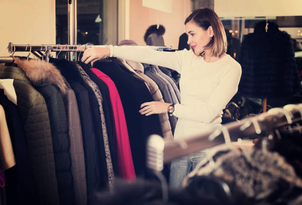 istock Young female customer examining red woolen coat 804607860