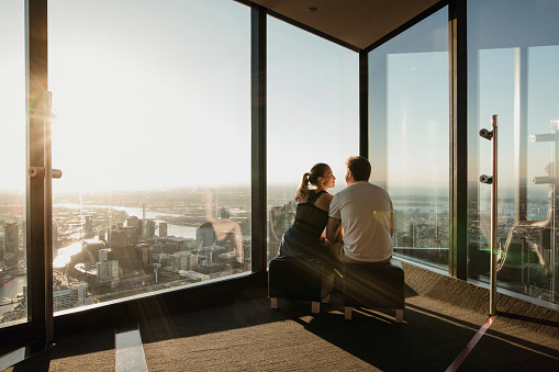 Young couple enjoying the view from the Eureka Skydeck in Melbourne, Australia.