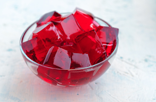 Cubes of red jelly in a glass bowl