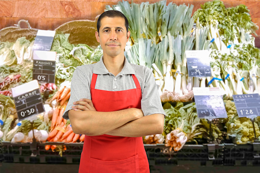 portrait of shopman at the vegetables store with crossing arms