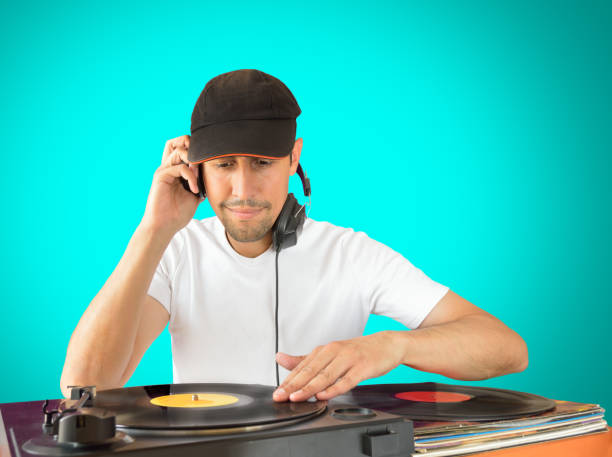 DJ mixing DJ mixing vinyl record on a  turntable with green background dubstep photos stock pictures, royalty-free photos & images