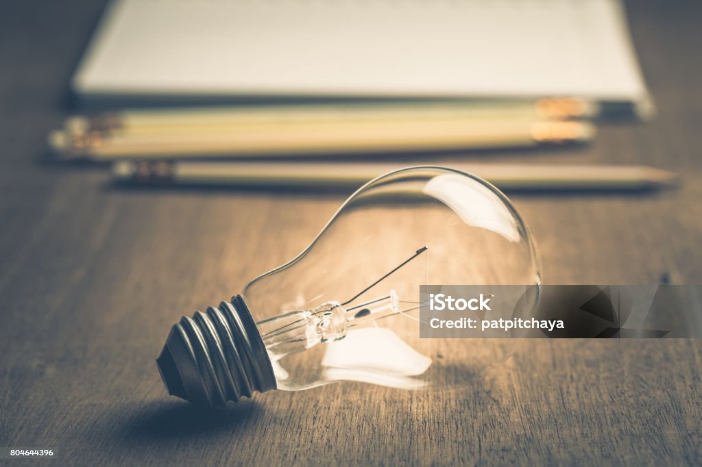 Idea For Writing Light bulb with pencils and notebook on background Blogging Stock Photo