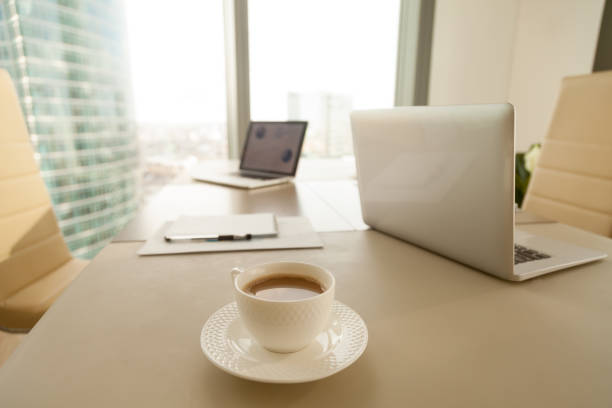 istock Modern office workplace, coffee cup, laptops on conference negotiating table 804671320