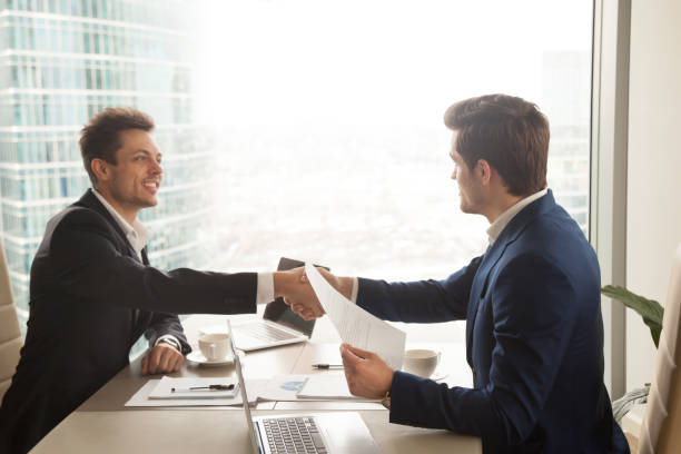 istock Two businessmen handshaking over office desk, making deal, accepting offer 804671328