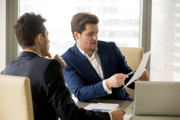 istock Two serious business partners discussing document, businessmen negotiating about contract 804671358