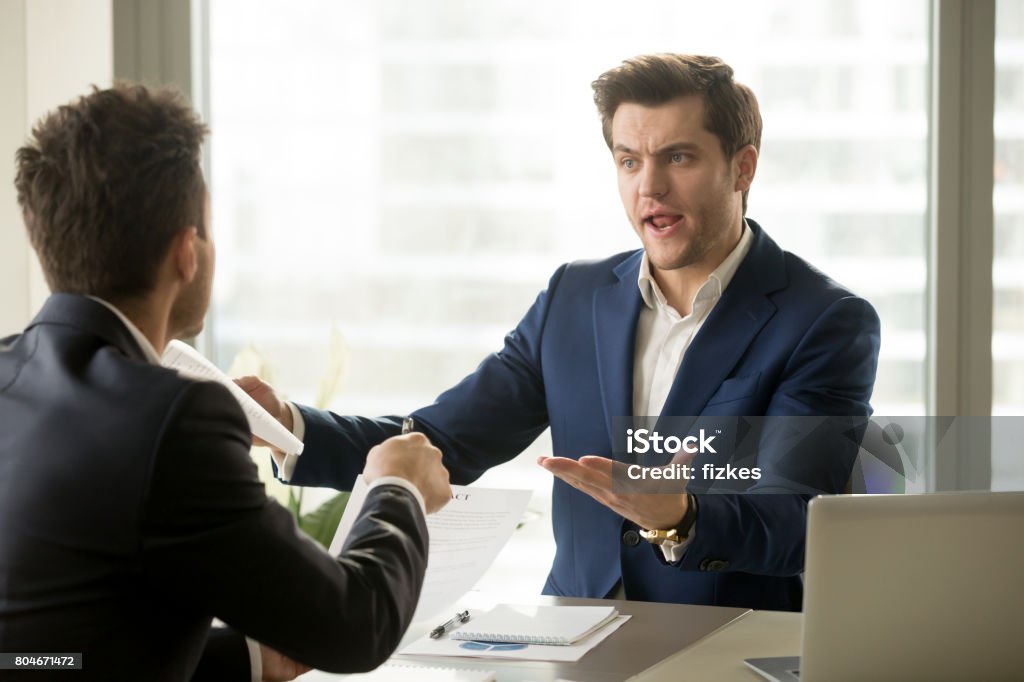 Businessmen arguing at workplace, deal failure, breaking contract, unacceptable terms Businessmen arguing at workplace, disagreeing over document, partners having conflict while negotiating, business deal failure, agreement cancelation, breaking contract, unacceptable terms Anger Stock Photo