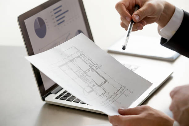 istock Male hand holding project plan, statistics on screen, close up 804671574
