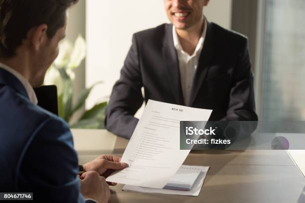 Employer Conducting Job Interview Reviewing Good Resume Of Successful Applicant Stock Photo - Download Image Now