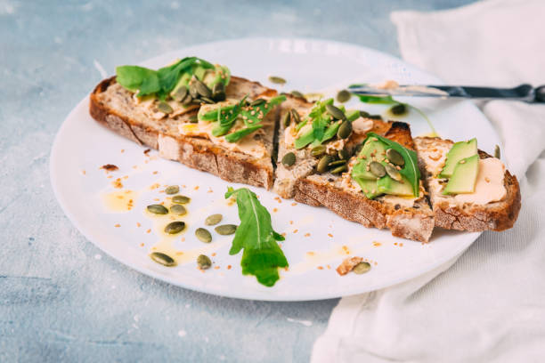 toasted rye bread with sliced avocado and herbs, simple rustic sandwich