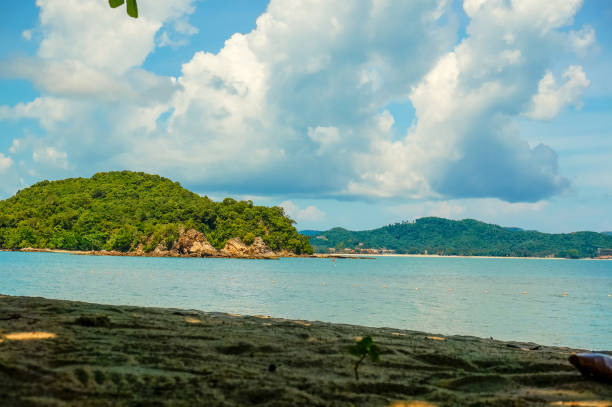 istock Shaded beach with blue ocean, cloudy sky and an island 804675138