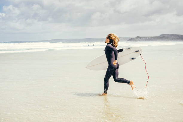 istock Surfer running into the sea, Newquay, Cornwall 804685042