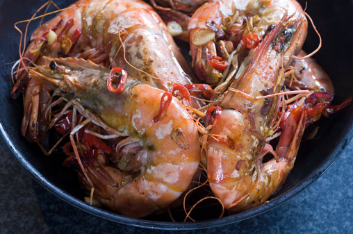Delicious cooked shrimps isolated on dark background. Boiled prawns