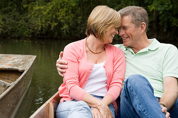 Affectionate mature couple on a rowboat  couple punting stock pictures, royalty-free photos & images