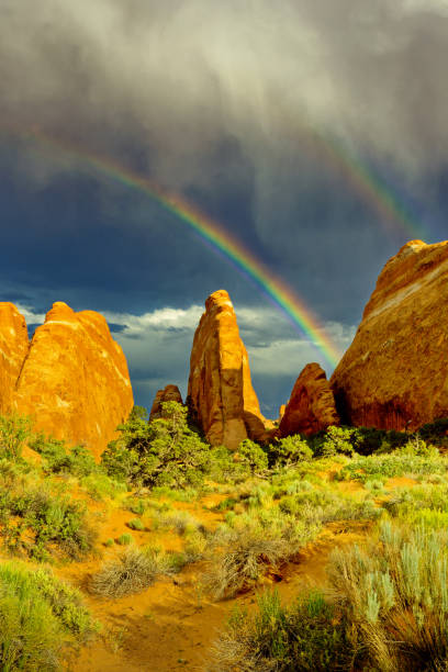 istock Rainbow, rain clouds, and sunlit sandstone formations in Utah 804702898