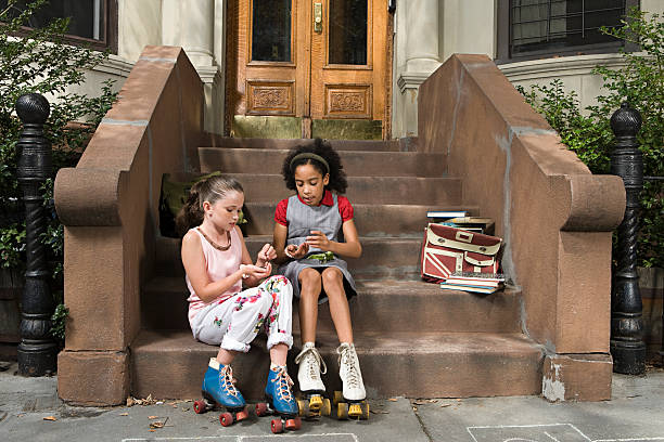 Girls sitting on steps  doorstep stock pictures, royalty-free photos & images