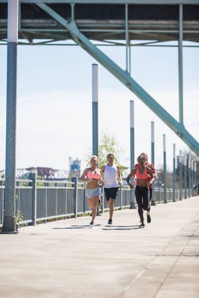 istock Co-Ed group running and exercising together outdoors in the sunshine 804724036