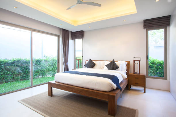 Luxury Interior design in bedroom of pool villa with cozy king bed. Bedroom with high raised ceiling stock photo