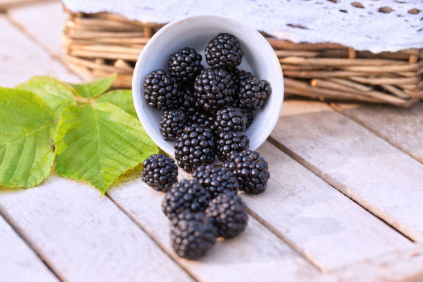 istock Blackberries in a white cup on a wooden table 804767280