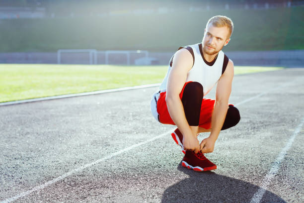 istock Sportsman crouched in red sneakers 804780284