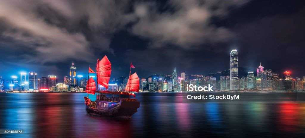 Victoria harbor in Hong Kong Tourist junk crossing the victoria Harbor in Hong Kong Urban Skyline Stock Photo