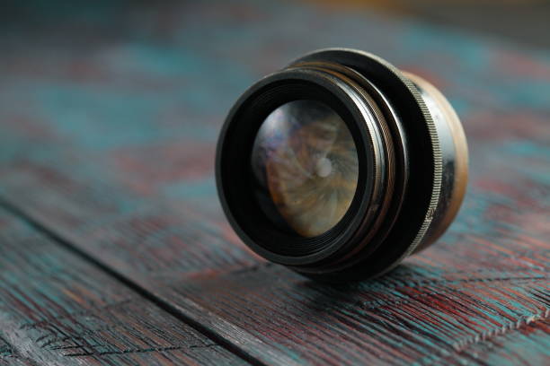 Old lens from old camera on the wooden table