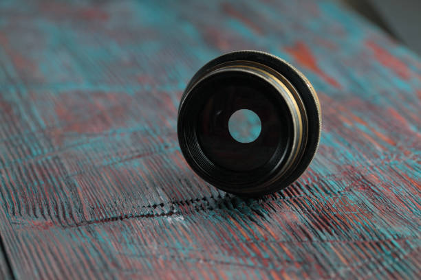 istock Old lens from old camera on the wooden table 804820052
