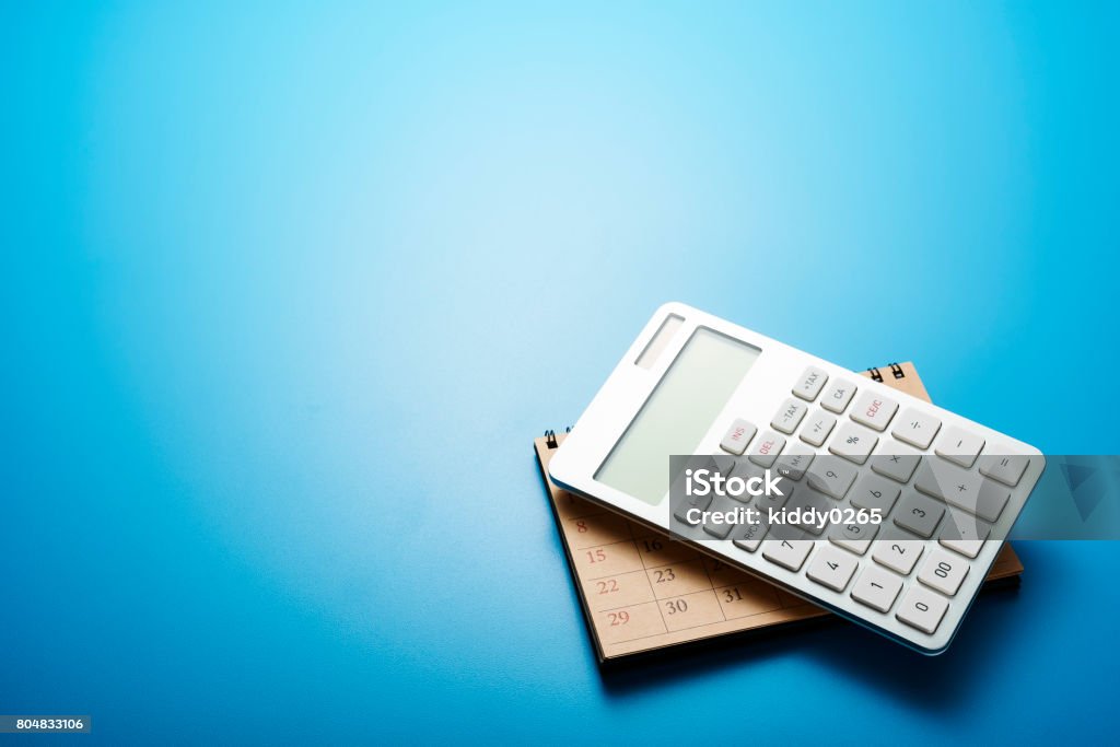 Deadline. Office supply on blue background with copy space.Work tools on desk table. Shot with top view. Calculator Stock Photo