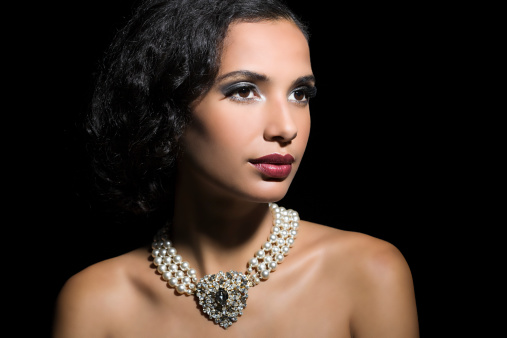 Stylish pearl necklace on jewelry bust against white background