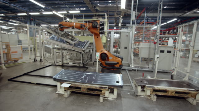 CS Industrial robot moving molded aluminum plates in the factory
