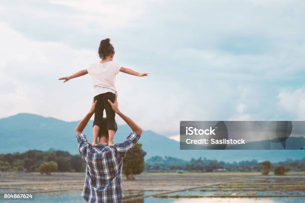 Foto de Menina Asiática De Pé No Ombro Do Pai E Brincando Juntos e mais fotos de stock de Pai