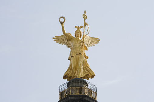 The Prussian eagle and Iron Cross isolated on blue sky, part of Quadriga of the Brandenburg Gate in Berlin, Germany.