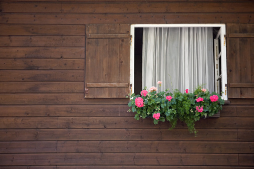 Old wooden window with shutters of an old small wooden cottage in Malopolskie Province, Poland.