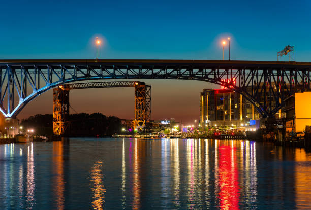 Flats East Bank CLEVELAND, OH - JUNE 17 2016: The east bank of the Cuyahoga, under highway and railroad bridges, glows with the lights of a new vibrant entertainment district. cuyahoga river photos stock pictures, royalty-free photos & images