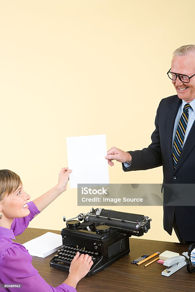 A secretary passing a businessman a document  Active Seniors Stock Photo