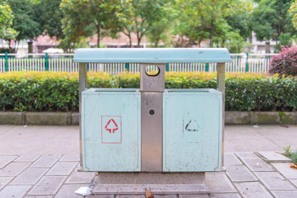 istock trash cans in the park beside walkway 804892854