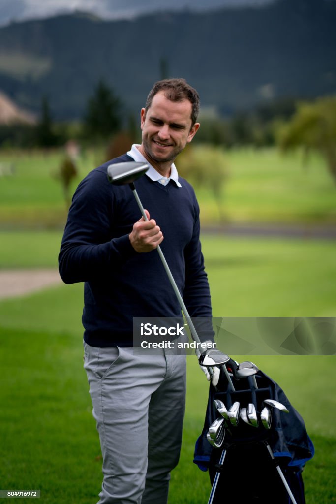 Man playing golf and choosing the club Portrait of a happy man playing golf and choosing the club - sports training concepts 40-49 Years Stock Photo