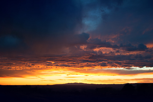 Clouds and orange sky,Real majestic sunrise sunset sky background with gentle colorful clouds without birds.Panorama, large