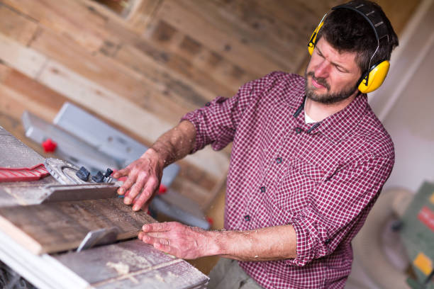 istock Male Carpenter cutting plank by circular saw 804929866
