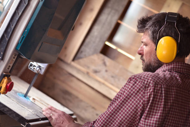 istock Male Carpenter cutting plank by band saw 804931306