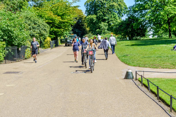 велосипедисты и джоггеры в лондонском парке - kensington gardens стоковые фото и изображения